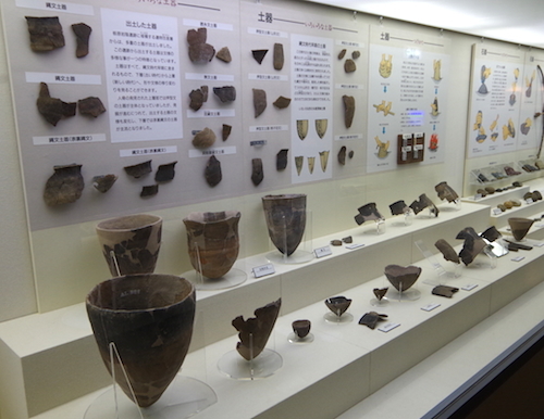 展示されている栃原岩陰遺跡出土の土器を左から見た画像